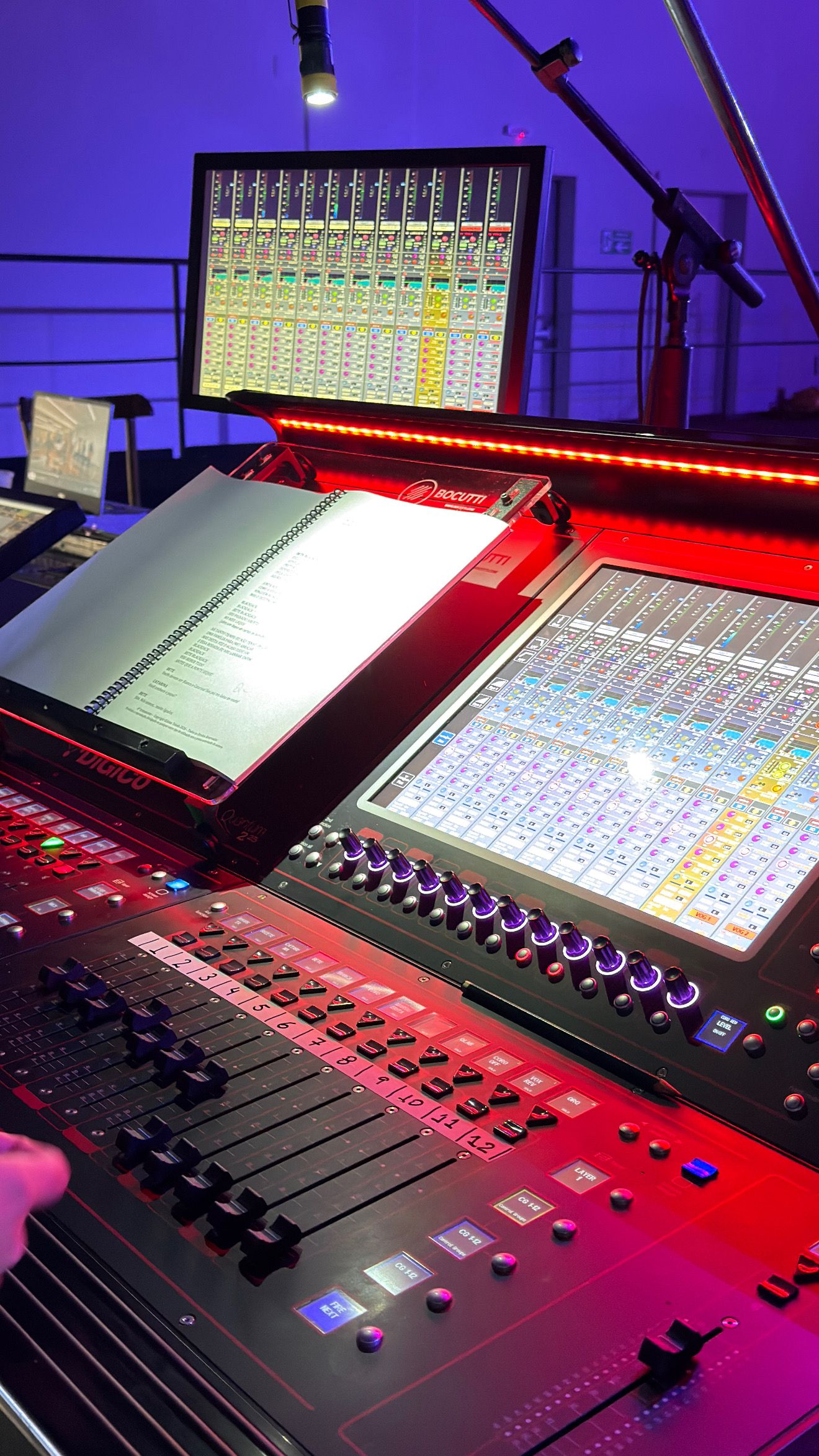 Script trolley Bocutti Audio no console DiGiCo Quantum 225 com iluminação de palco em tons de roxo e vermelho